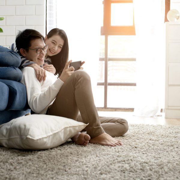 happiness asian sweet couple enjoy game on smartphone together living room home background